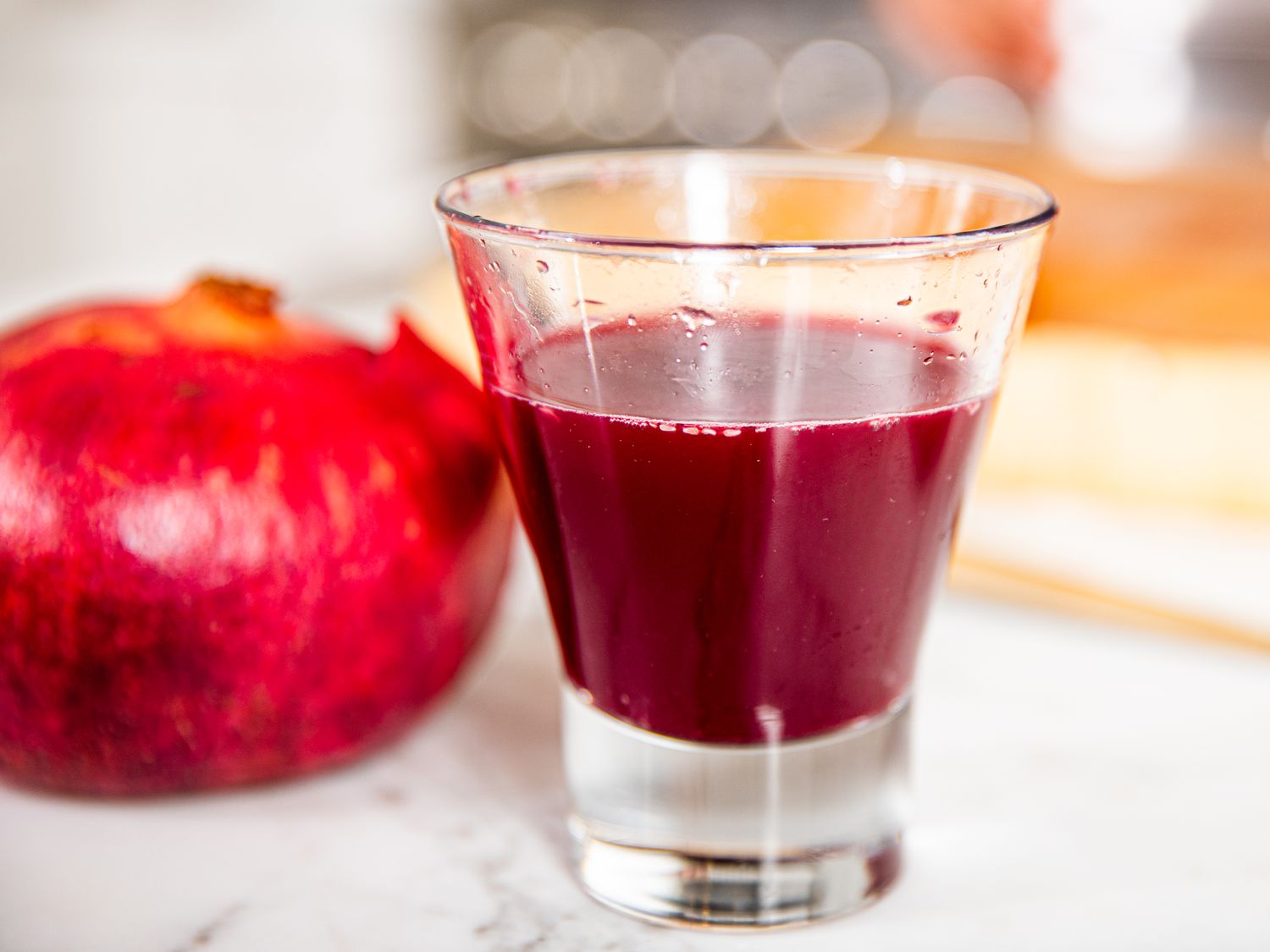Side view of a glass of pomegranate juice 