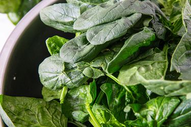 A bowl filled with fresh spinach leaves