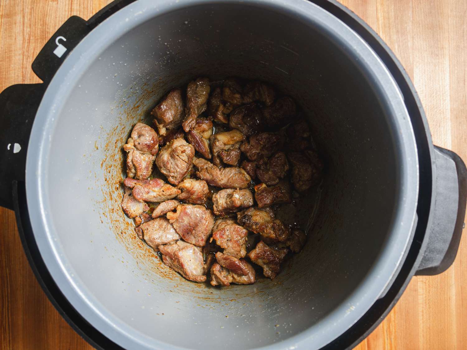 Overhead view of lamb cooking in a dutch oven 