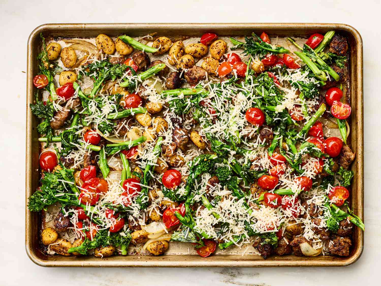 Baked sheet pan gnocchi with vegetables and shredded cheese