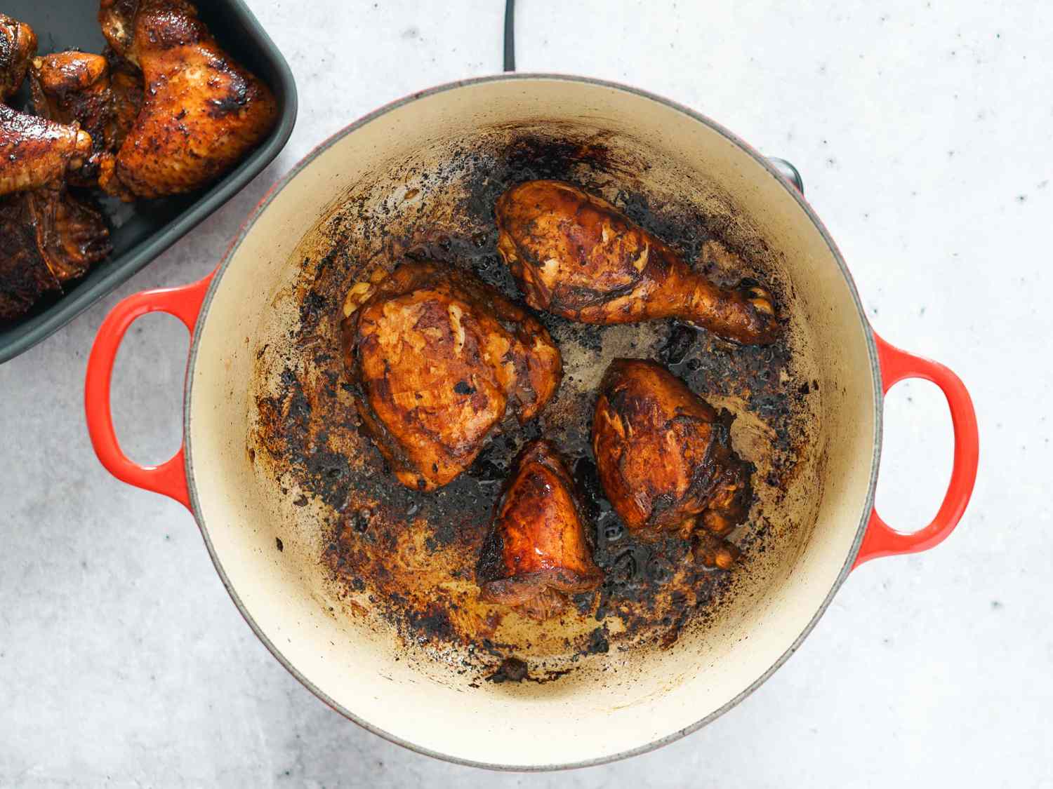 Chicken pieces being browned in a Dutch oven