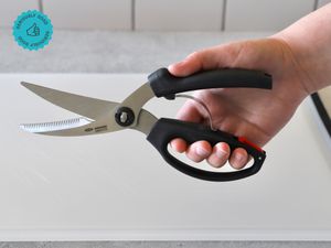 A person holding a pair of poultry shears.