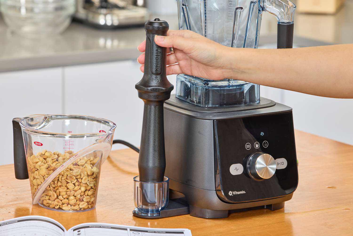 a hand holding an accessory of the Vitamix Ascent X5 Blender