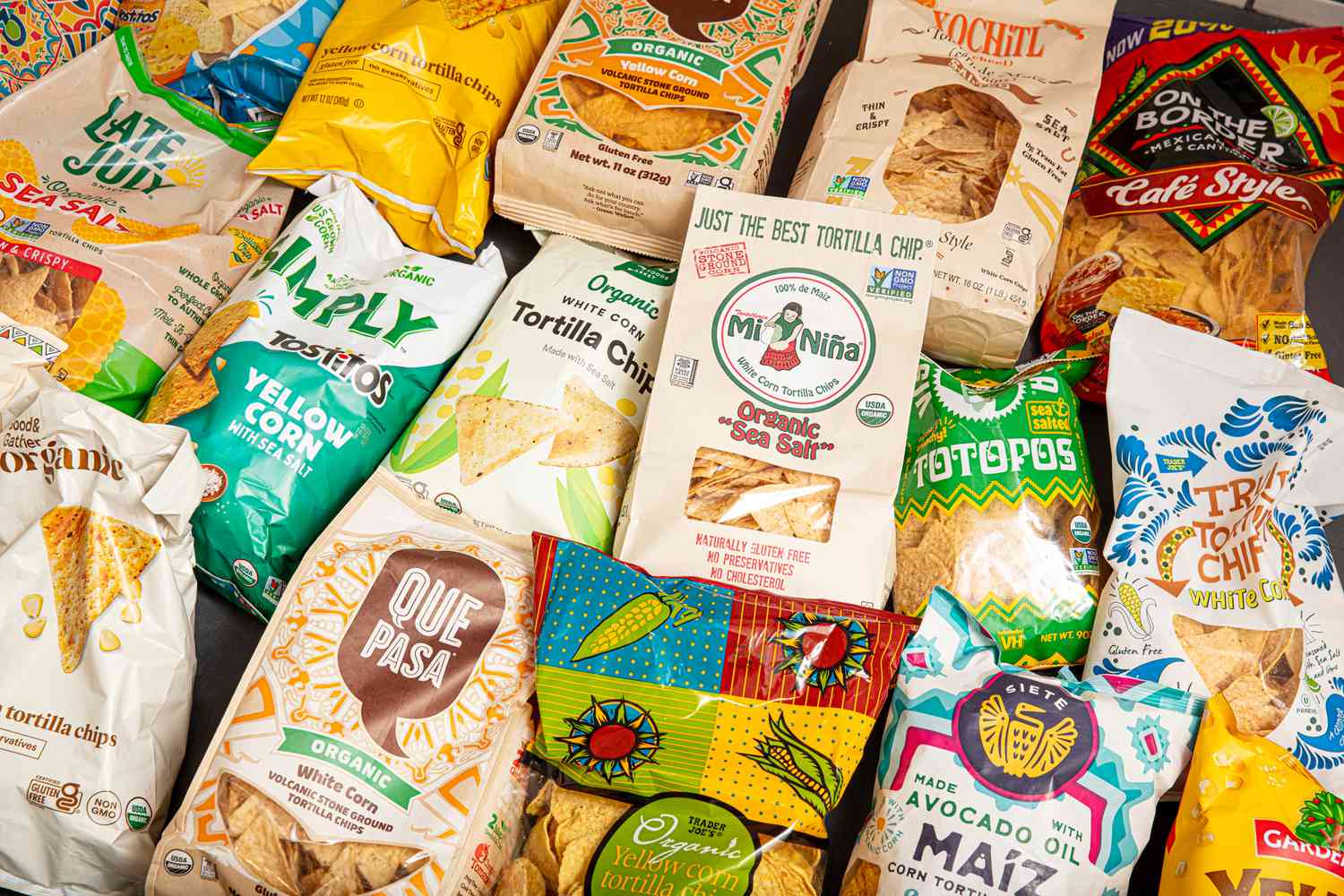 Variety of tortilla chip brands displayed on a surface
