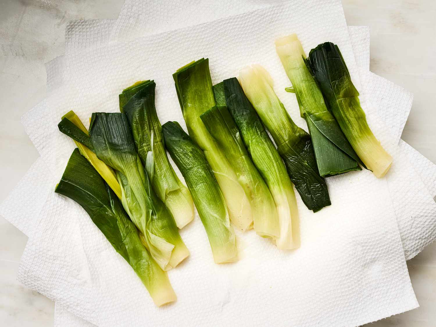 Boiled leek stalks arranged on paper towels