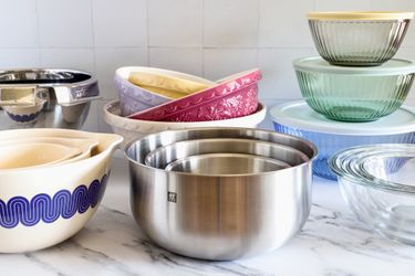 Various mixing bowls arranged on a counter featuring metal ceramic and glass designs