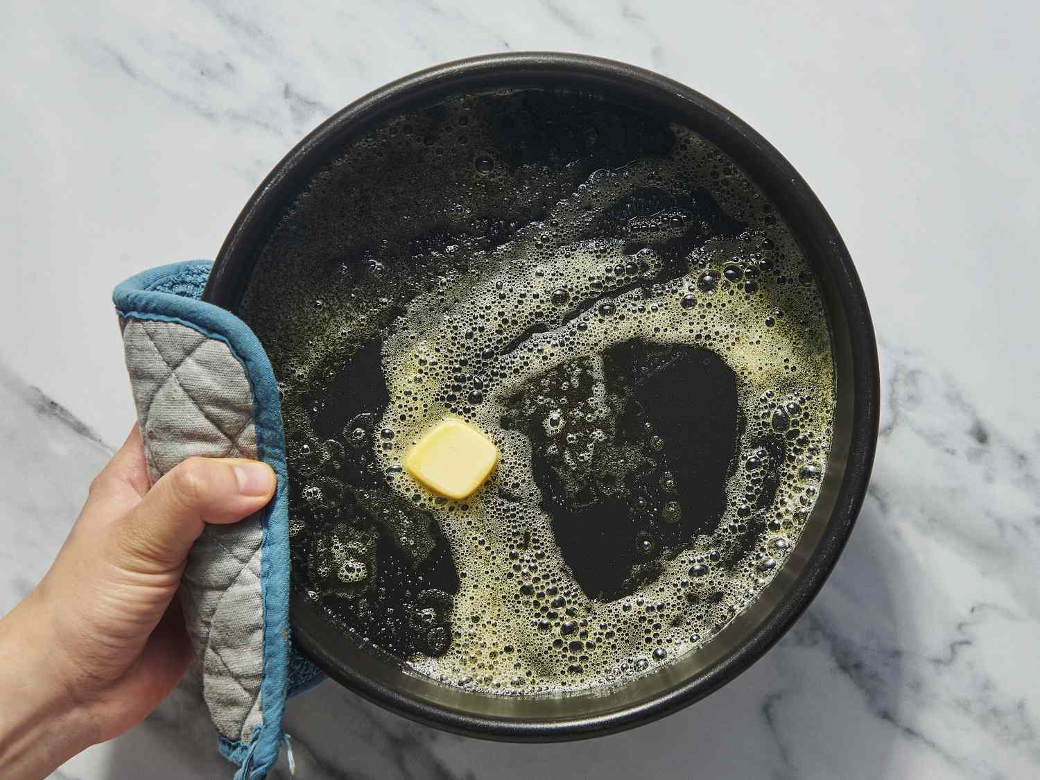 Overhead view of butter melting in pan