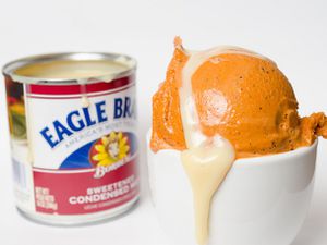 Scoop of Thai tea ice cream drizzled with sweetened condensed milk