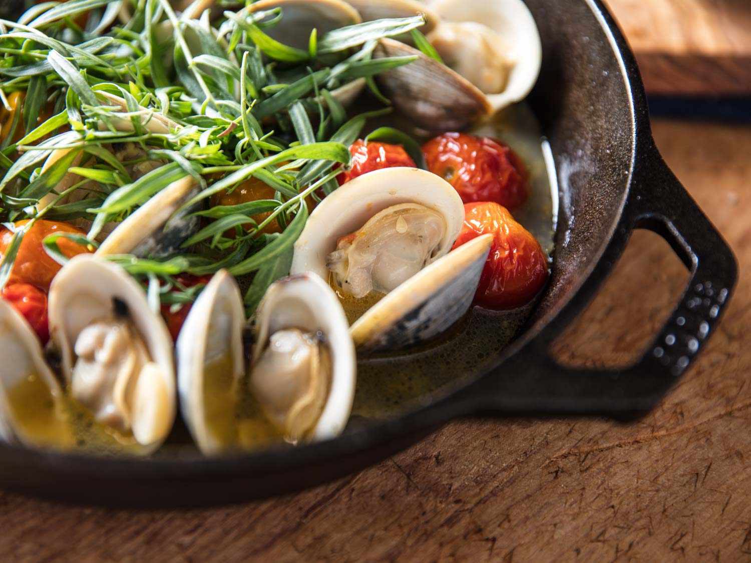Close up of final broiled clams with cherry tomatoes and tarragon