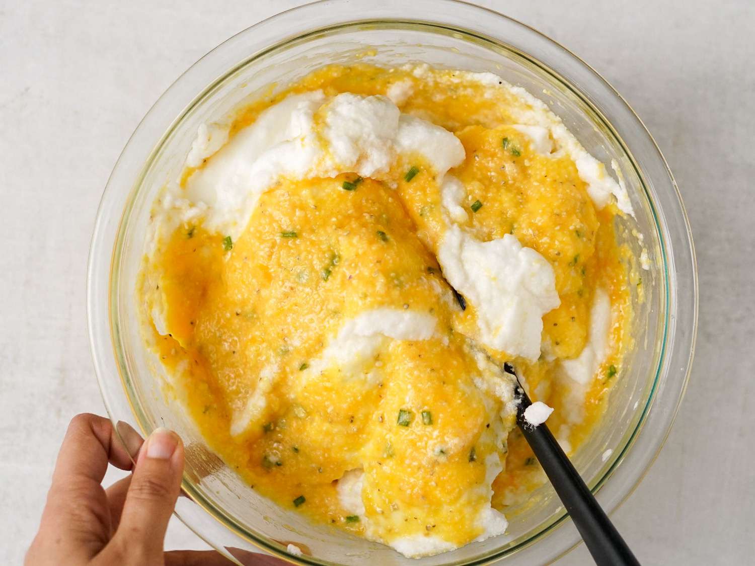 The bowl of corn grits with whipped egg whites being folded in.