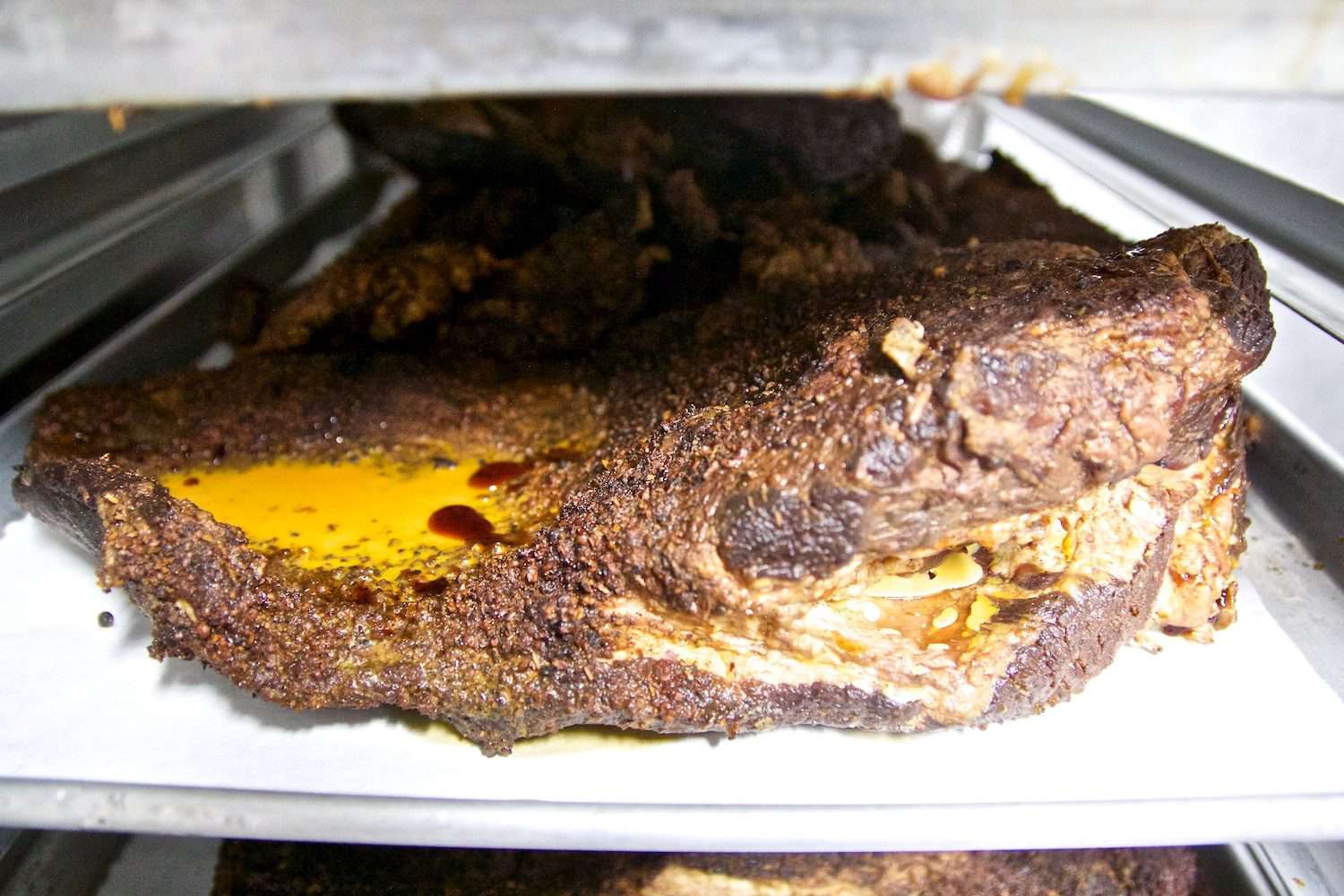 Pan of brisket sitting in refrigerator.