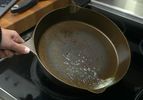 hand swirling melted butter in skillet