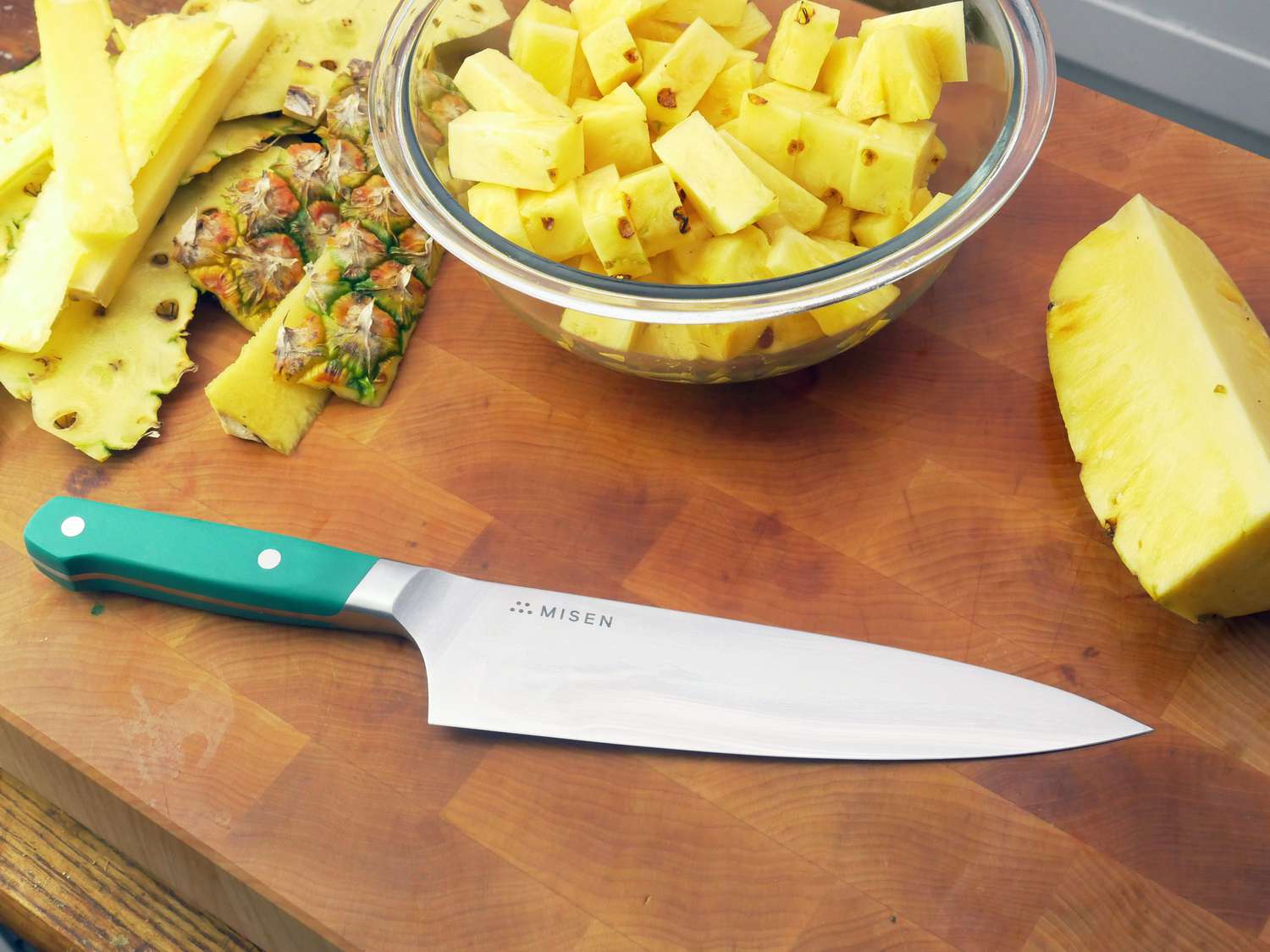 misen chef knife on a cutting board with diced pineapple