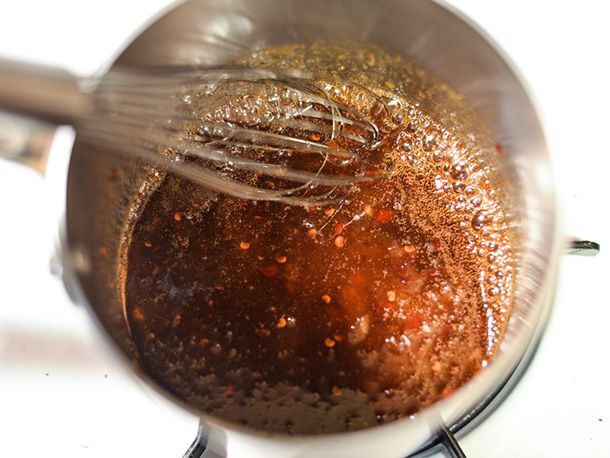 Overhead view of the glaze being whisked together in a saucepan.