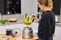 A person examines pesto made in the KitchenAid 13-Cup Food Processor