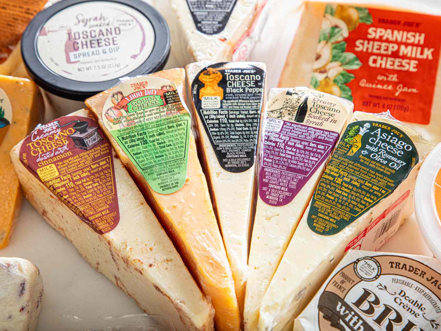 Assorted packaged cheeses including Toscano and Spanish sheep milk varieties displayed closely together