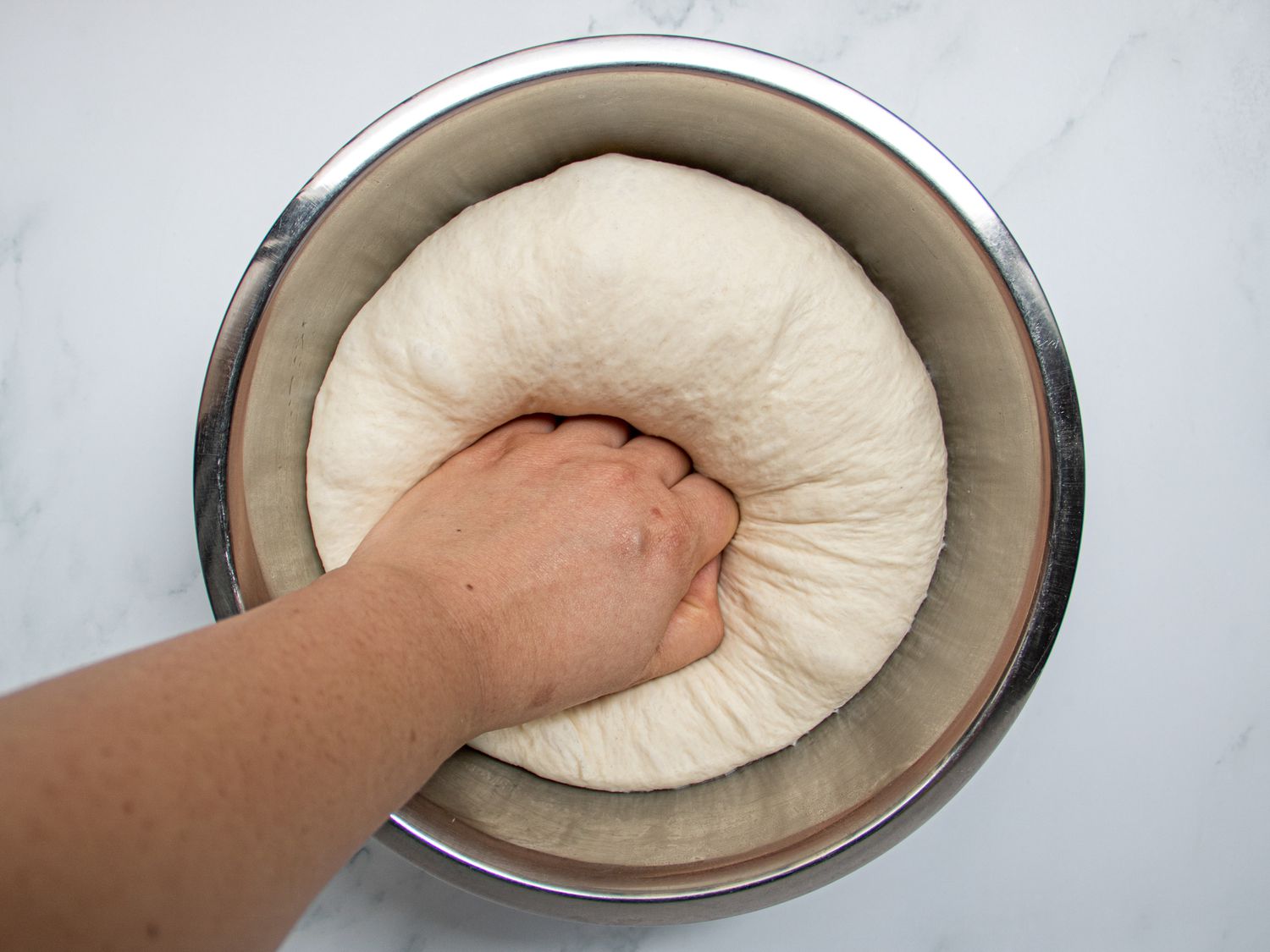 Overhead view of punching down in bowl