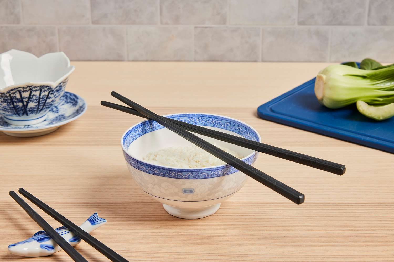 a bowl with rice and two chopsticks set on top