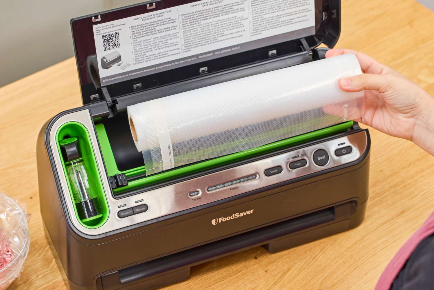 A person installing plastic bag cartilage into a FoodSaver V4400 2-in-1 Vacuum Sealer Machine