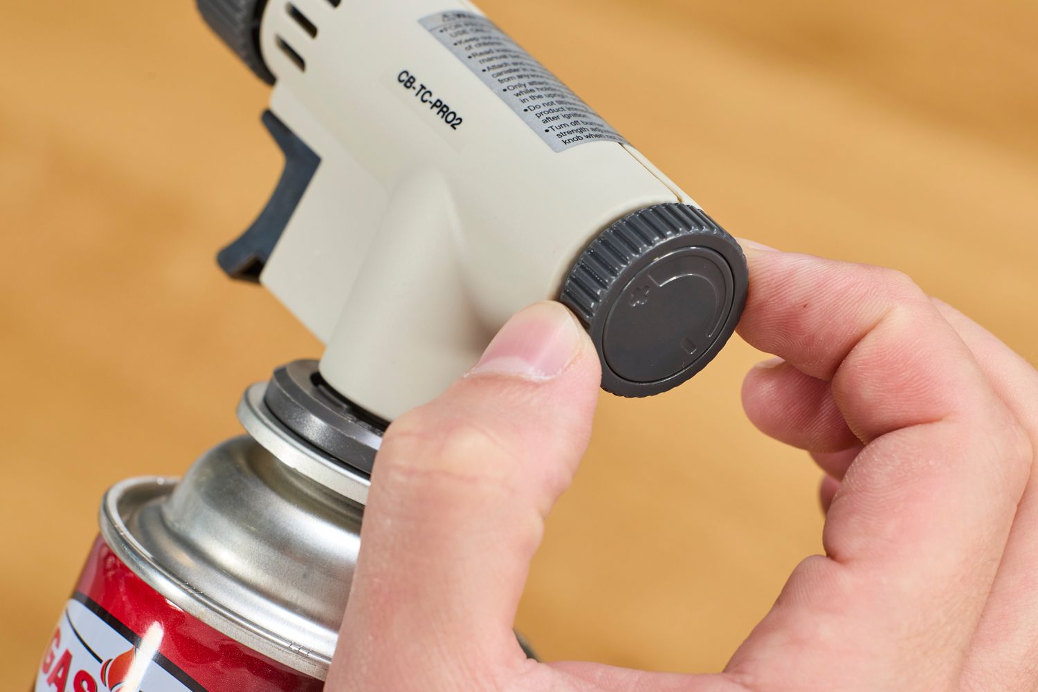 a person turning the dial on the iwatani torch