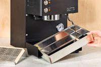 A person adjusting the tray under the Diletta Mio Espresso Machine