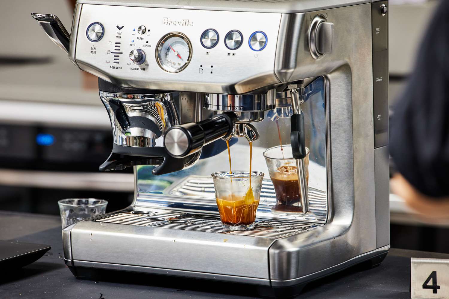 The Breville Barista Express Impress brewing an espresso into a glass 