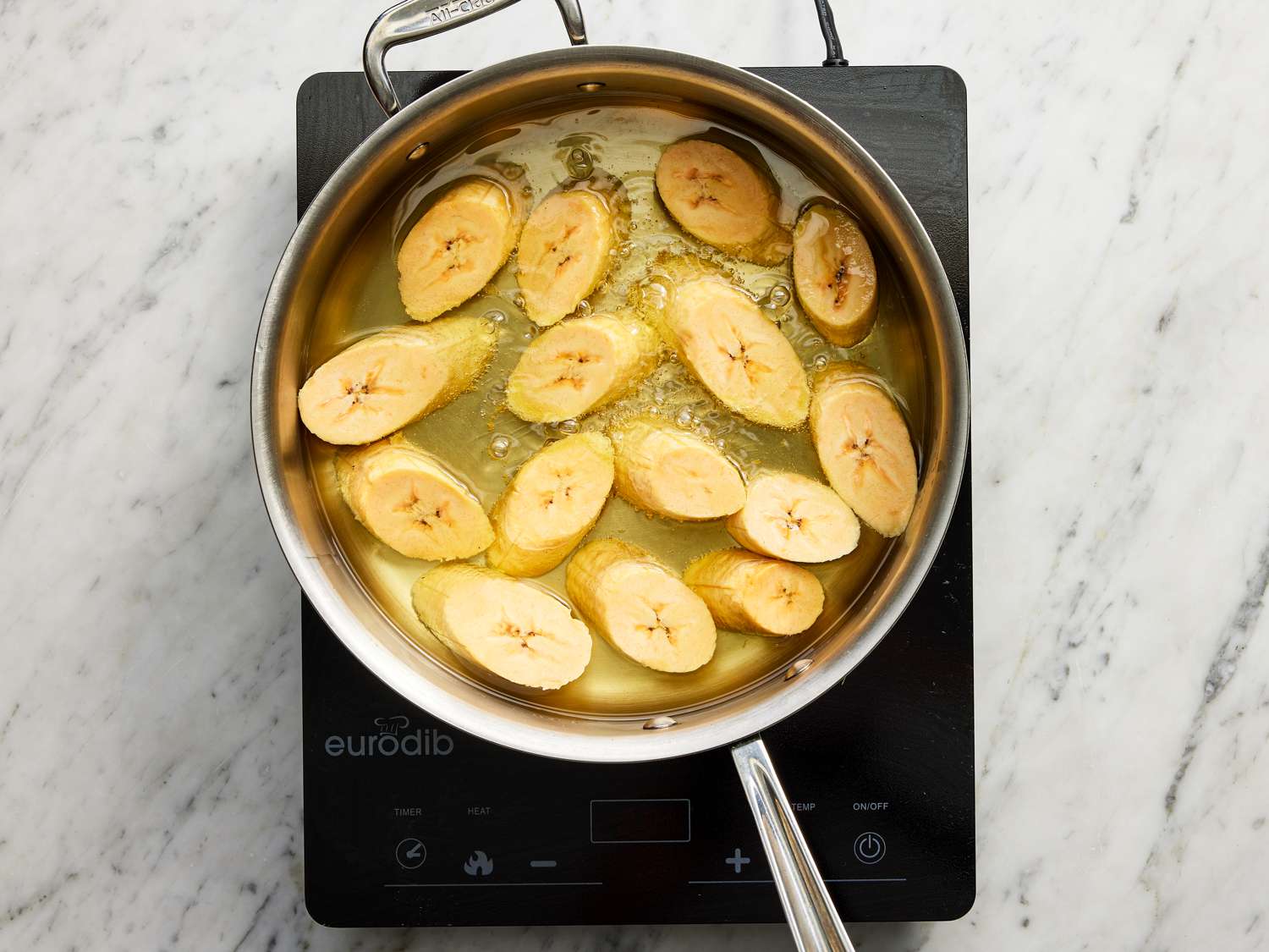 Overhead view of plantains frying in oil