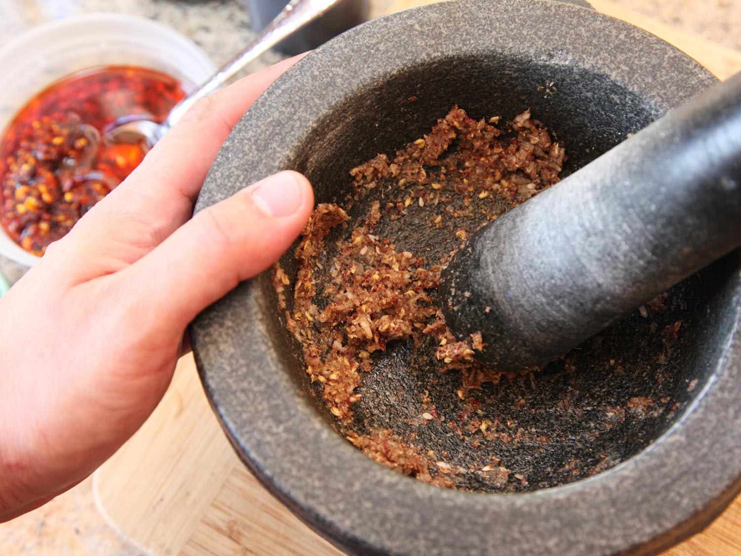 Chile, spices, and garlic ground into a paste in a mortar and pestle.