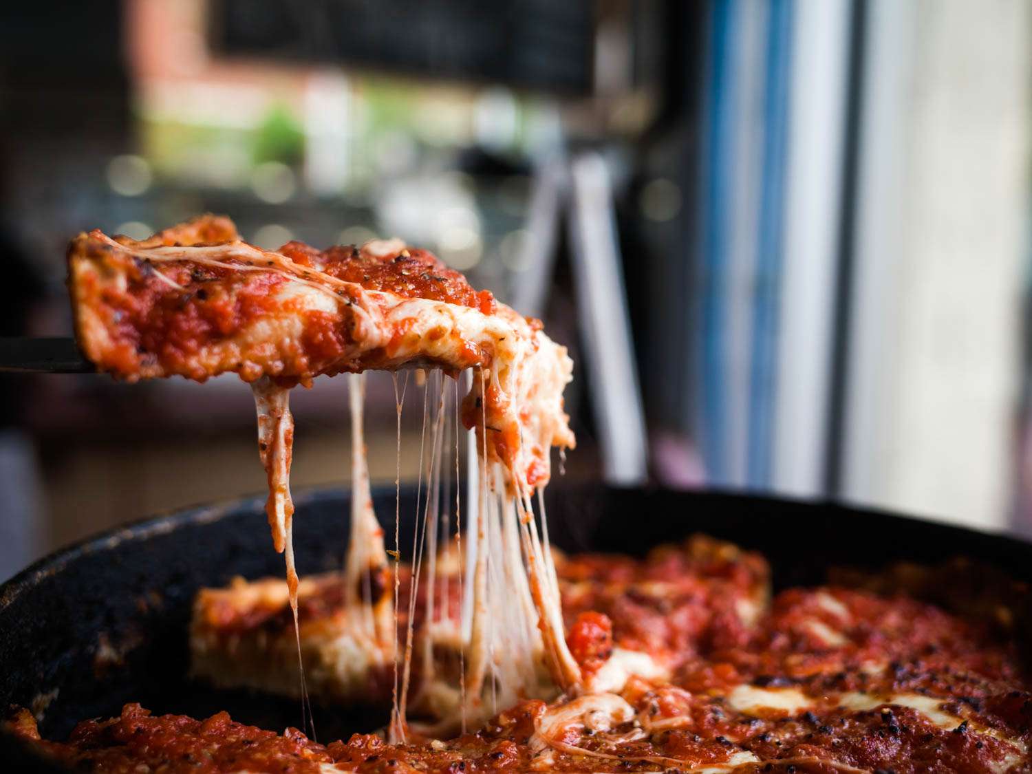 A slice of deep dish is raised from the pie at Mi Pi.