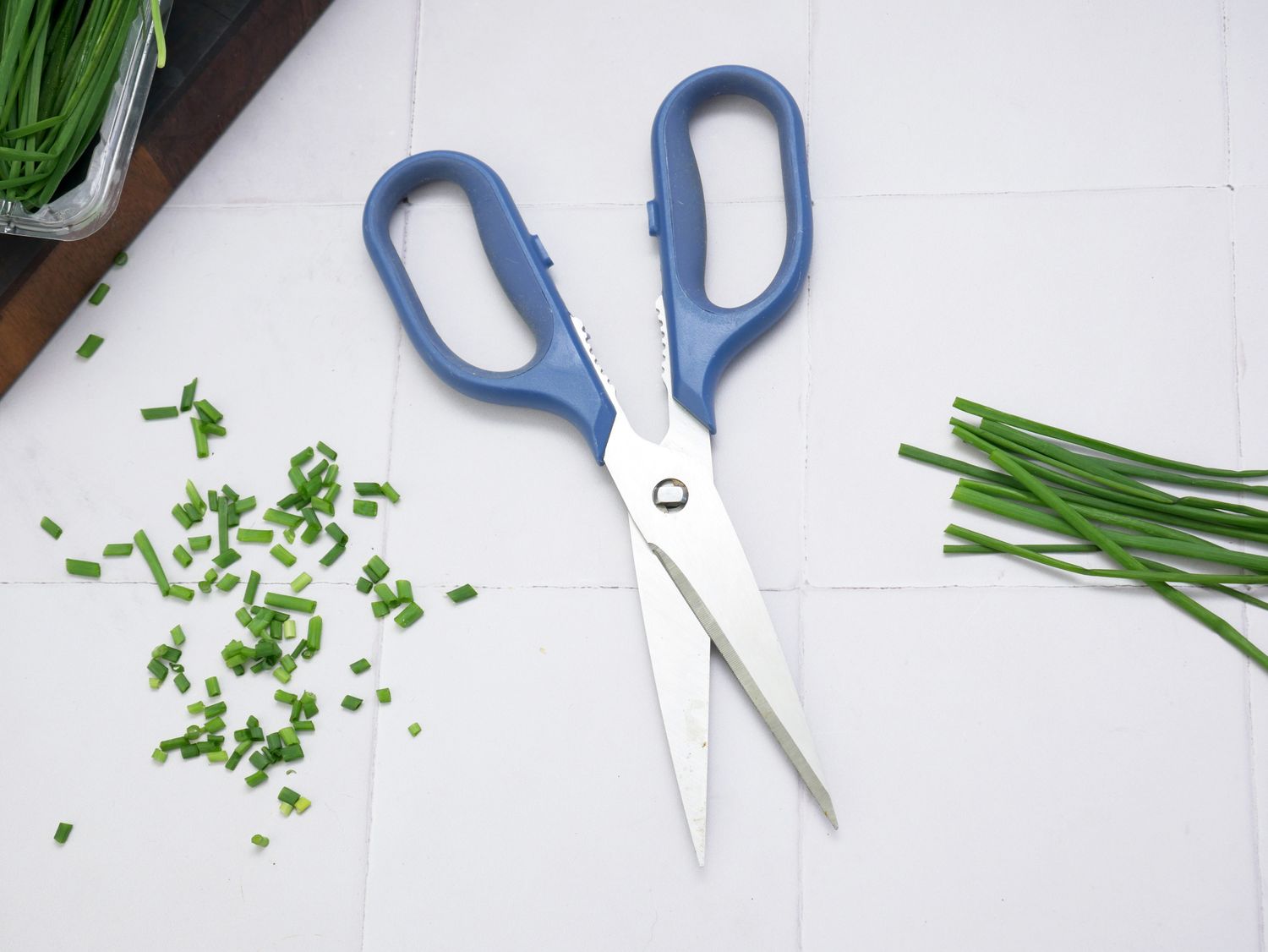 a pair of kitchen shears with chopped chives