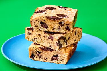 Three banana bread blondies stacked on a blue plate