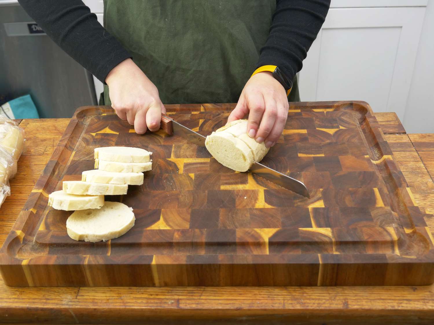 a person cutting bread on the yes4all wooden cuttingboard