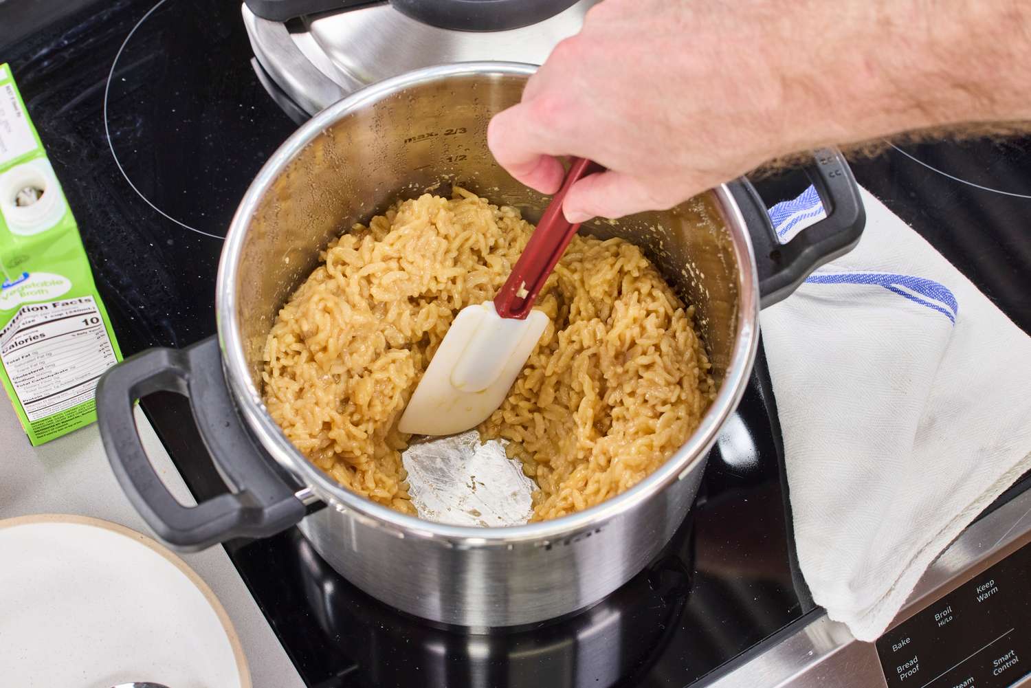 A person stirring cooked rice in the T-Fal Clipso Pressure Cooker