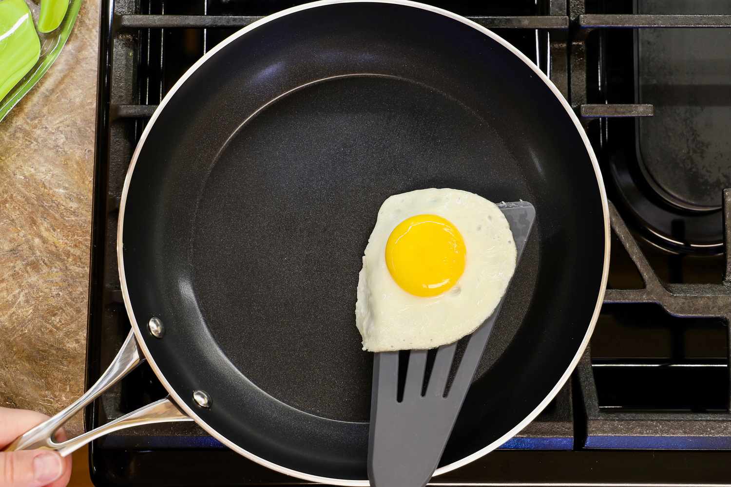 A fried egg on a spatula in a Kyocera ceramic frying pan