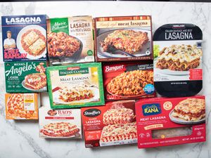 Various frozen lasagna packages arranged on a marble surface highlighting different brands and styles of lasagna