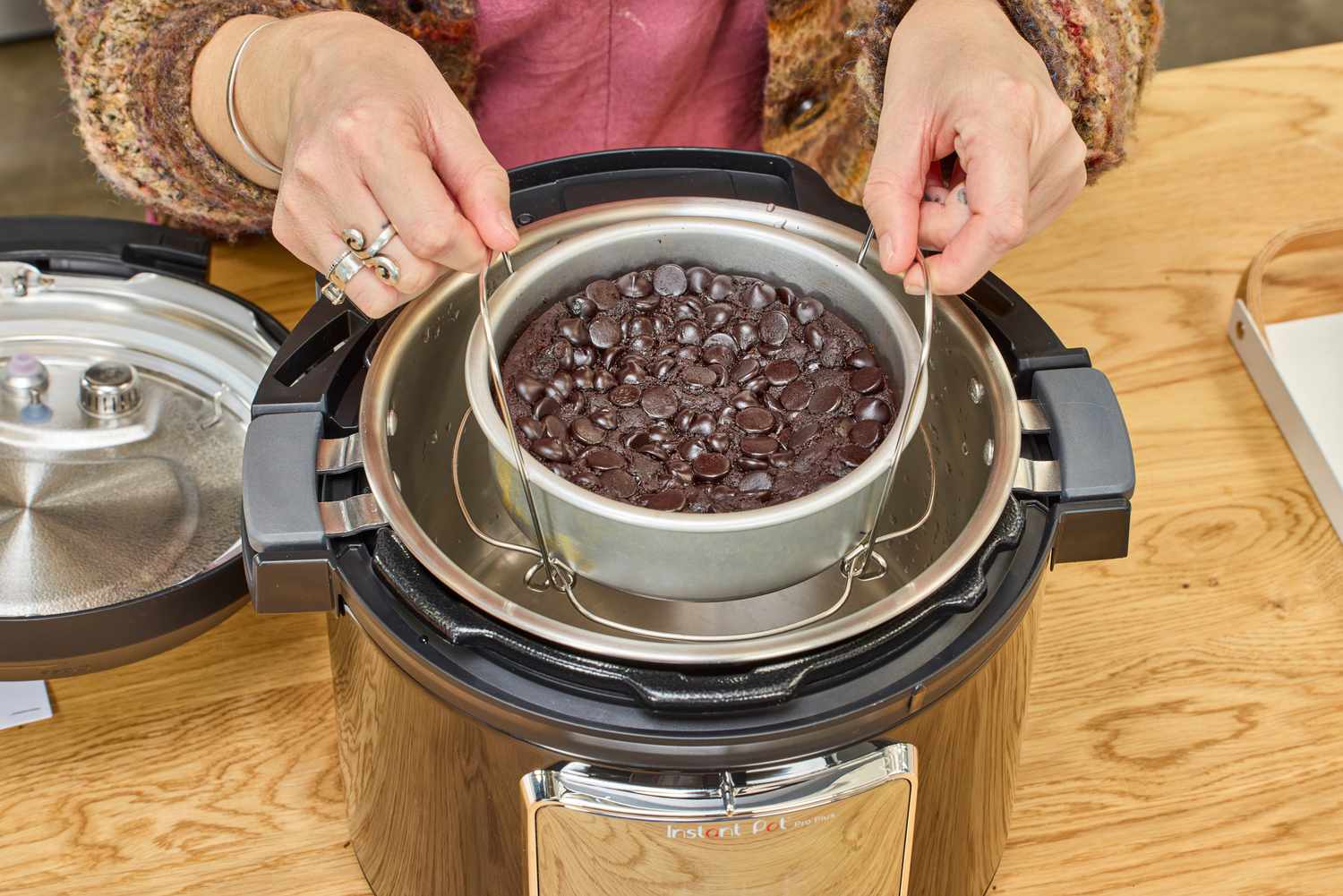A person removes a cake from the Instant Pot Pro Plus Wi-Fi Smart 10-in-1 6-Quart Pressure Cooker