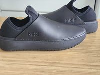 The Mise clogs on a wooden surface.