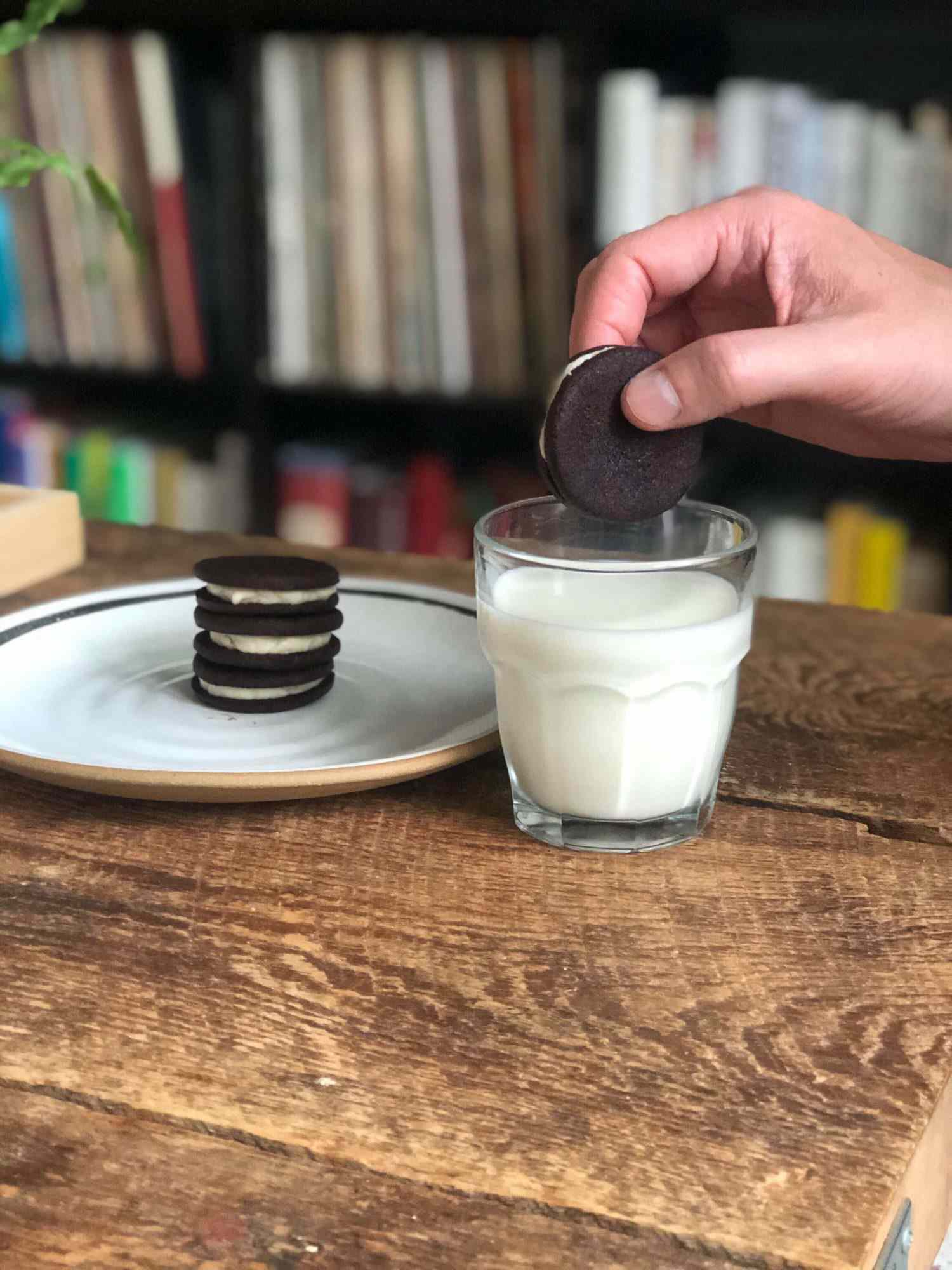 homemade oreo being dipped into glass of milk