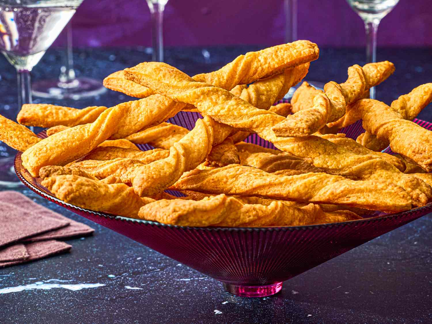 A decorative dish filled with twisted cheese straws placed on a table