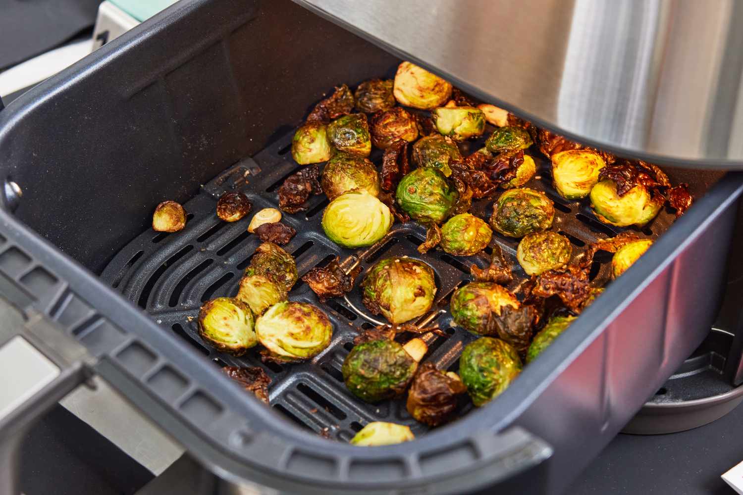 Crispy, browned Brussels sprouts in an air fryer basket