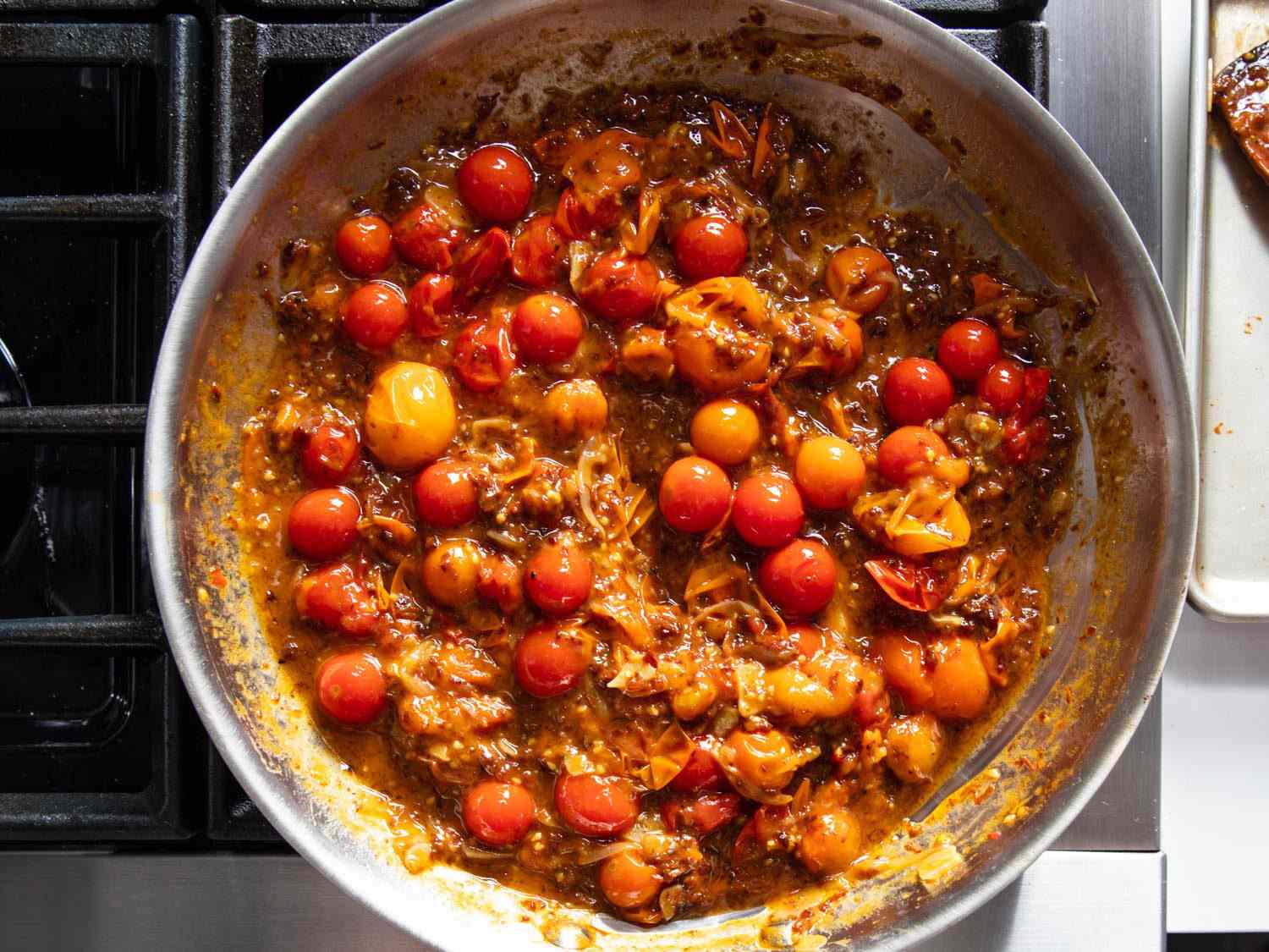 Overhead of skillet with sauce of burst cherry tomatoes and XO.