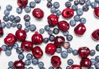 Blueberries and pitted cherries scattered on a white surface