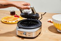 A round Breville waffle maker being opeend