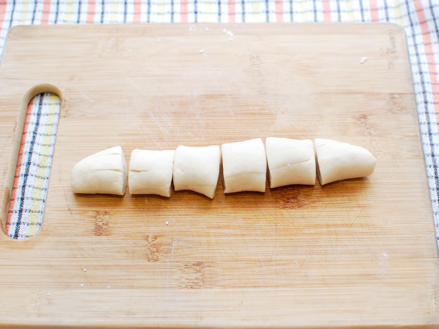 A dough quarter has been rolled into a cylinder and cut into 6 pieces.