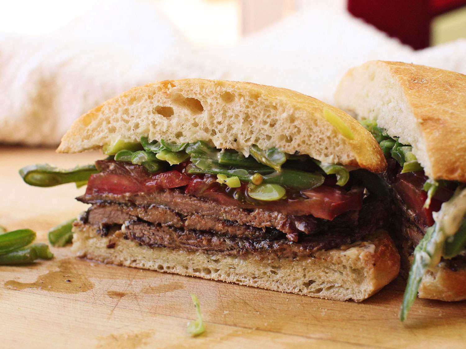 Chacarero Chileno (Chilean Steak and Bean Sandwiches) sliced open on a wooden cutting board