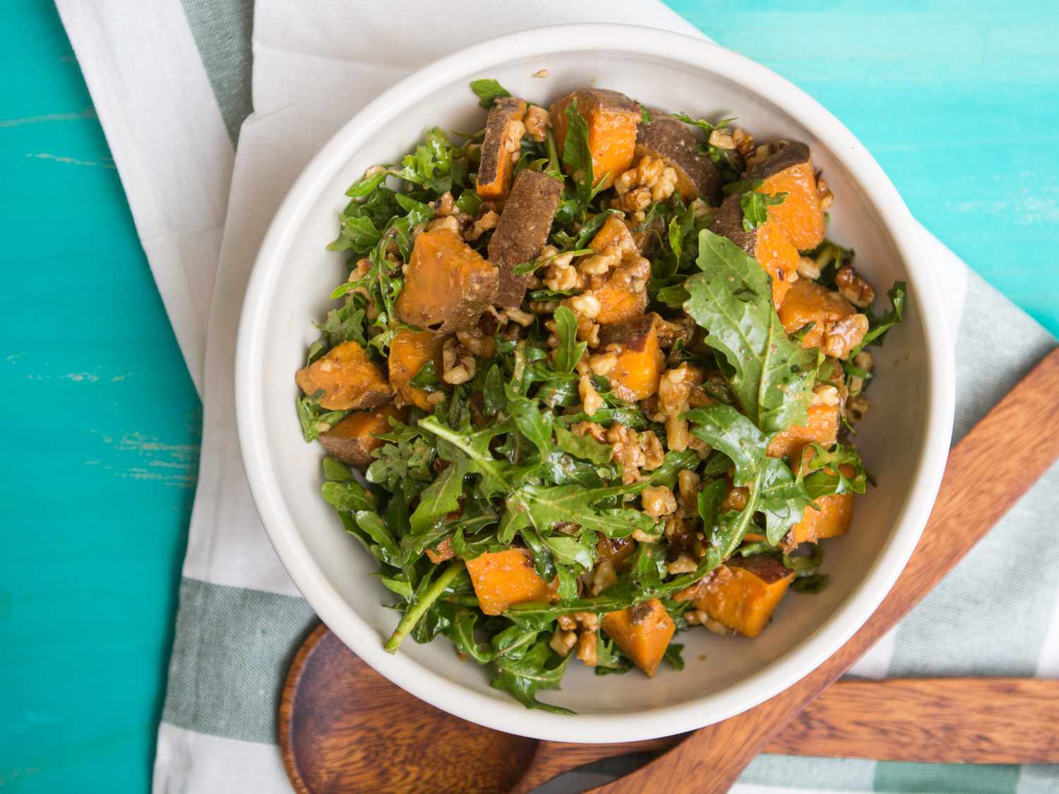 Overhead shot of a salad bowl of arugula, sweet potato, and toasted walnuts dressed with shoyu-dashi "vinaigrette".