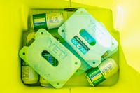 Yeti ice blocks and beverage cans inside a yellow cooler