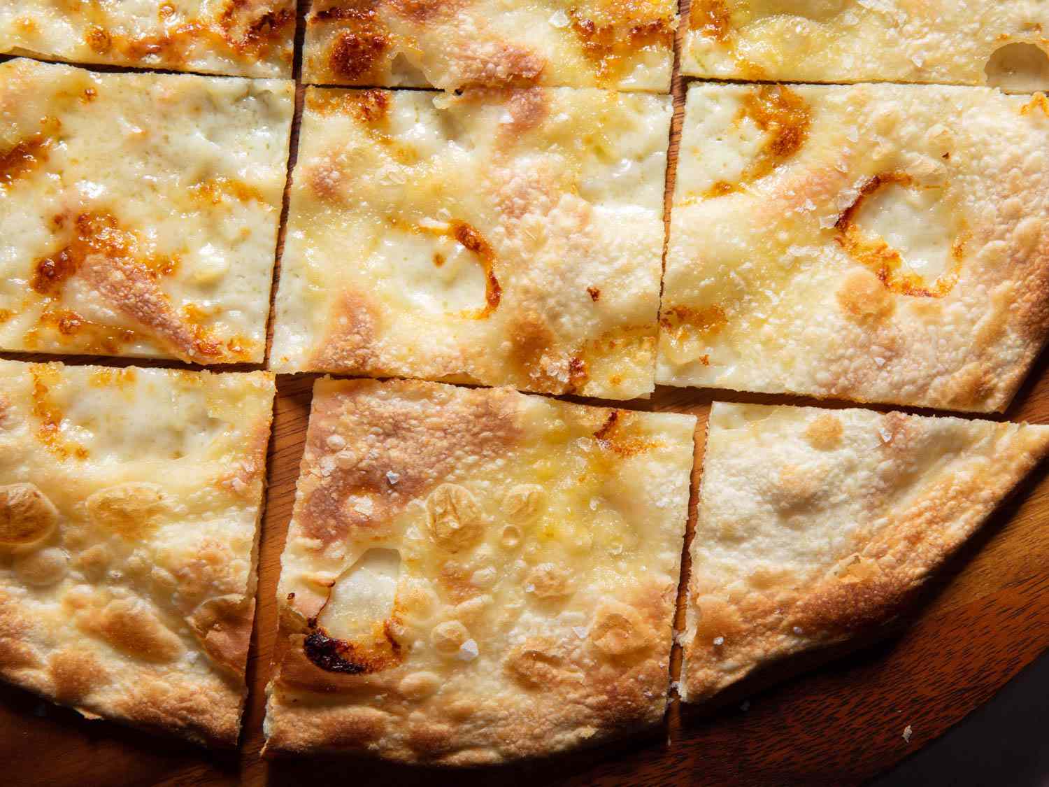 Closeup of finished focaccia di Recco cut into pieces.