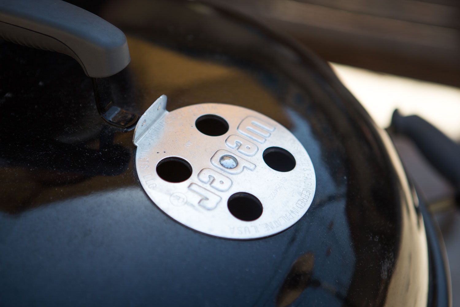 A close up of grill vents on a Weber kettle grill.