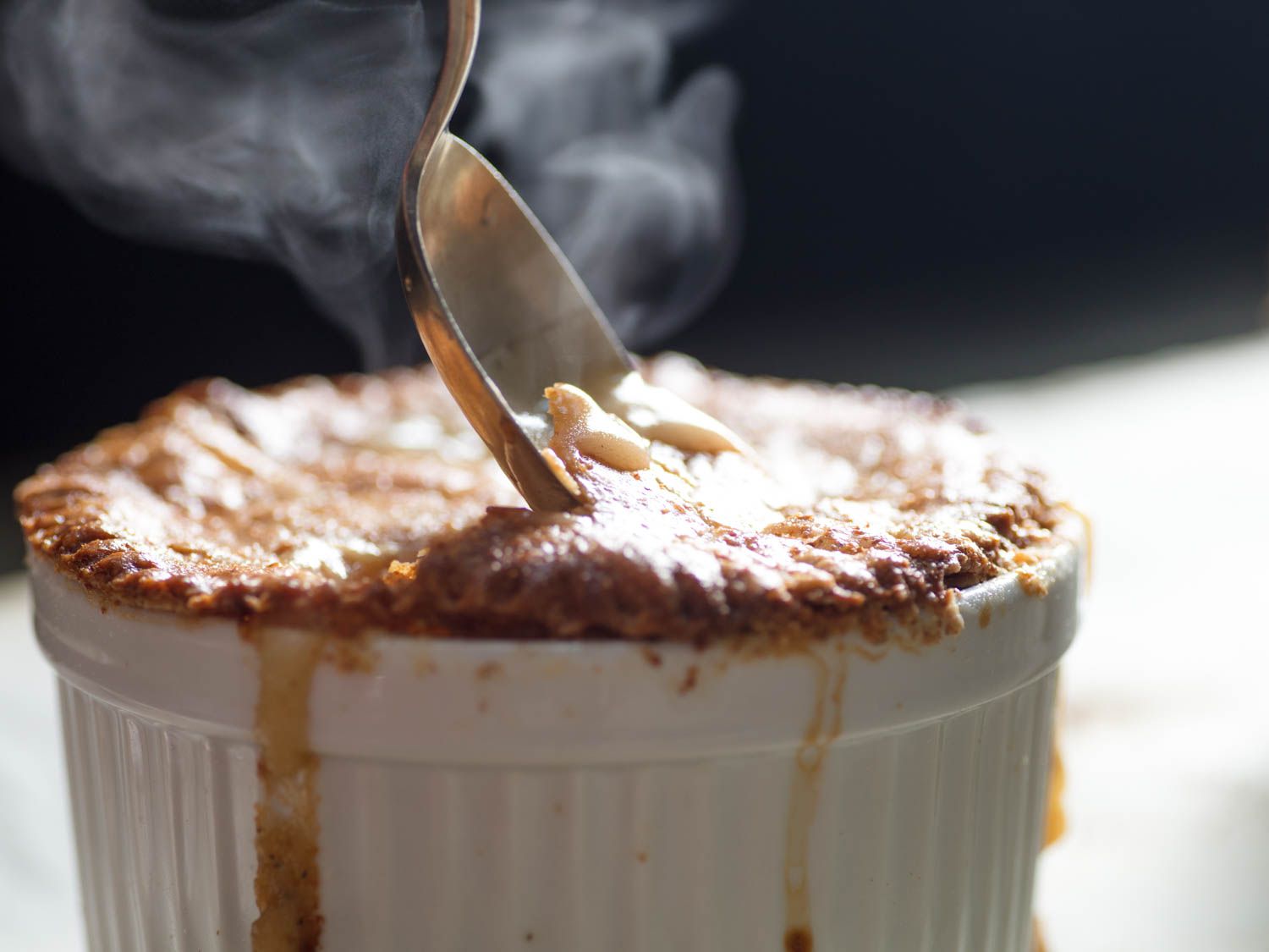 Spooning into a steaming hot individual chicken pot pie.